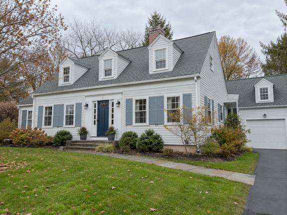 Warm white home with contrasting front door — Connecticut residential design inspiration