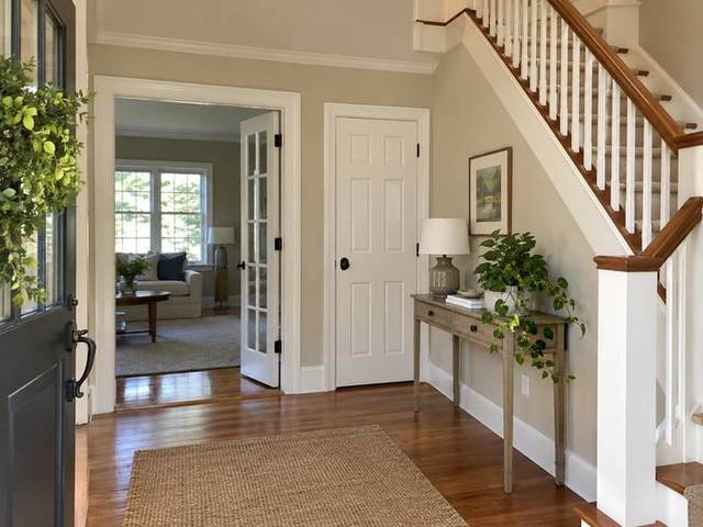 Light neutral entry hall with crisp painted doors — Connecticut residential design inspiration
