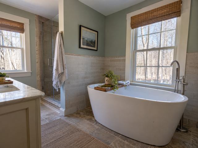 Freestanding bath beside neutral wall tile — Connecticut residential design inspiration